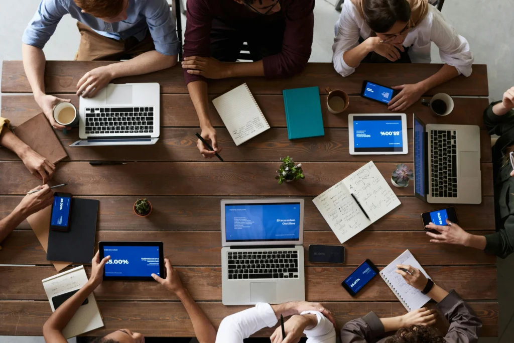 Meerdere collega’s in overleg aan tafel, als visuele verwijzing naar interne communicatie verbeteren