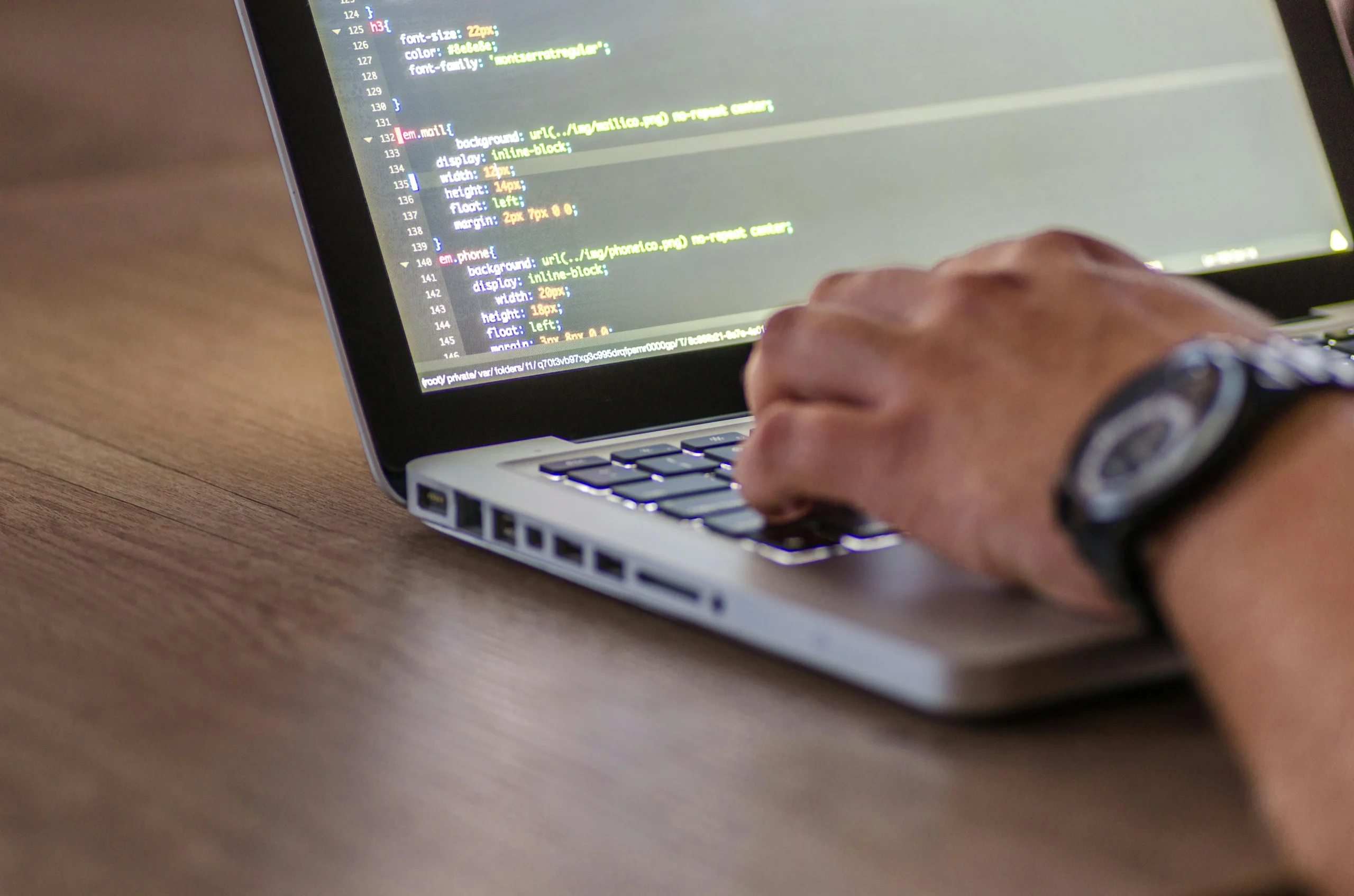 Man die aan het coderen is op laptop, als illustratie bij een artikel over web development