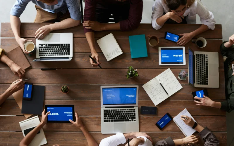 Meerdere collega’s in overleg aan tafel, als visuele verwijzing naar interne communicatie verbeteren