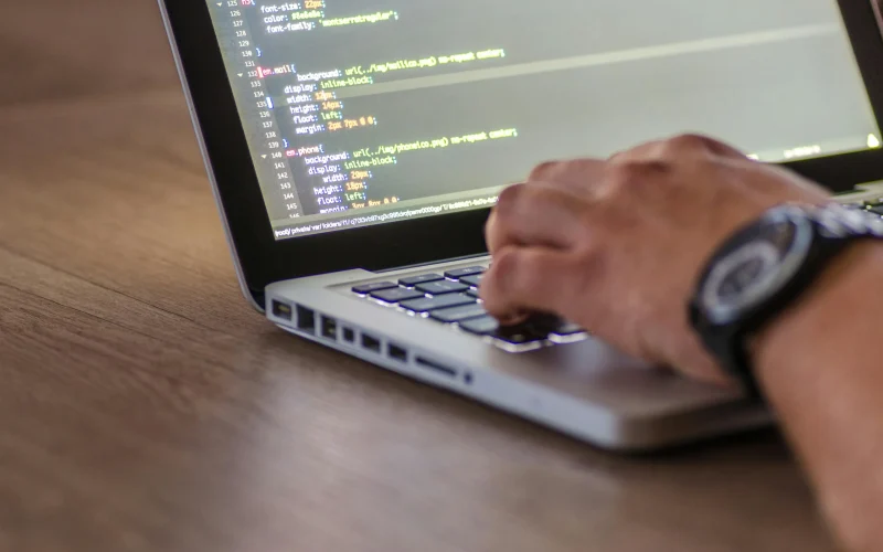 Man die aan het coderen is op laptop, als illustratie bij een artikel over web development